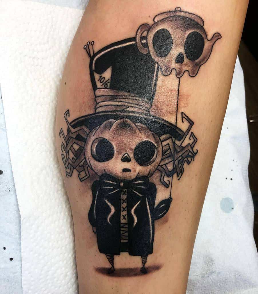 Black and gray tattoo of a skeleton Mad Hatter from Alice in Wonderland, with a teapot shaped like a skull floating above him