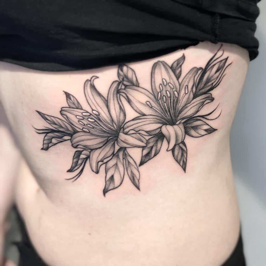 Elegant black and grey tattoo of two blooming lilies with fine shading and bold outlines