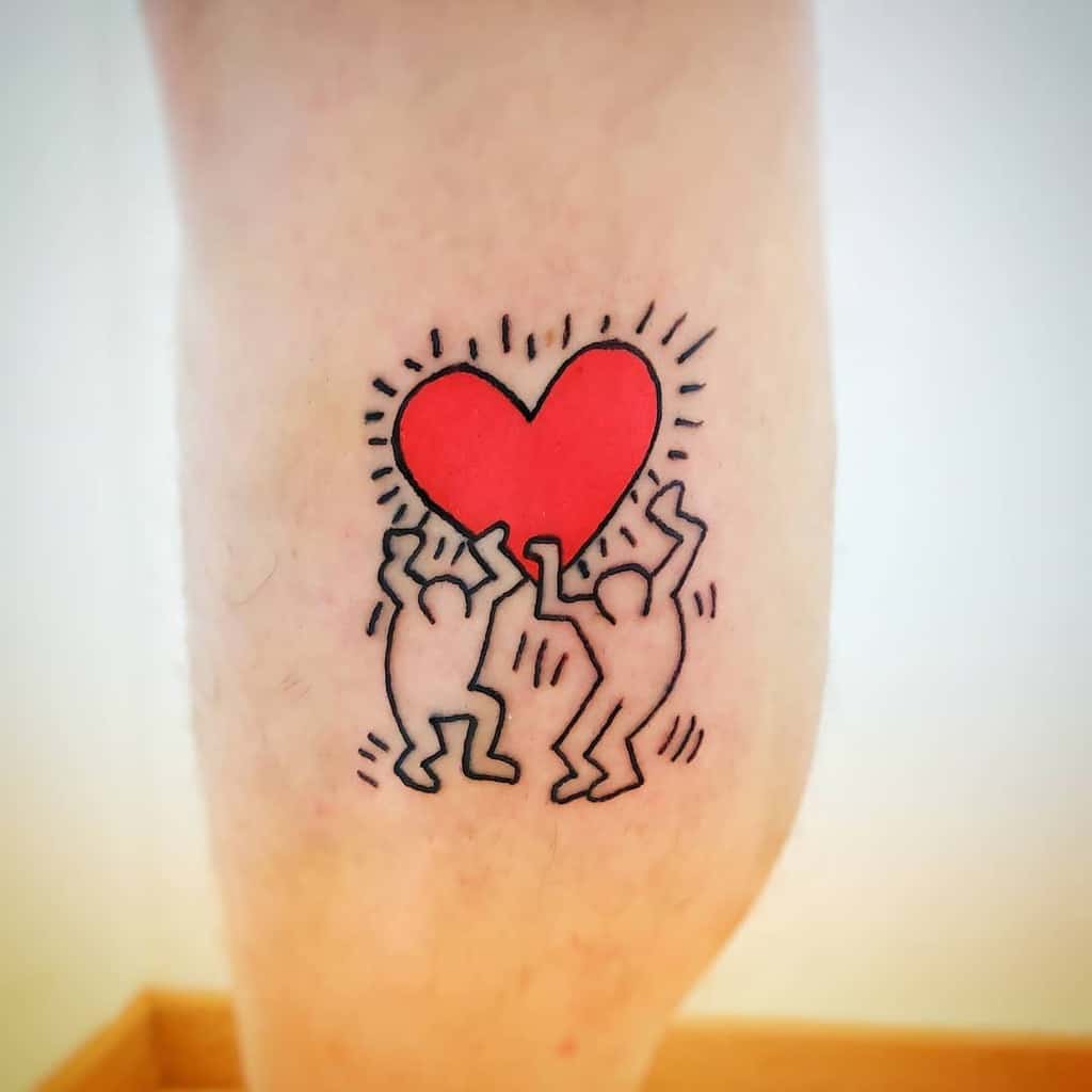 Minimalist tattoo inspired by Keith Haring, featuring two dancing figures holding a bright red heart with radiating lines