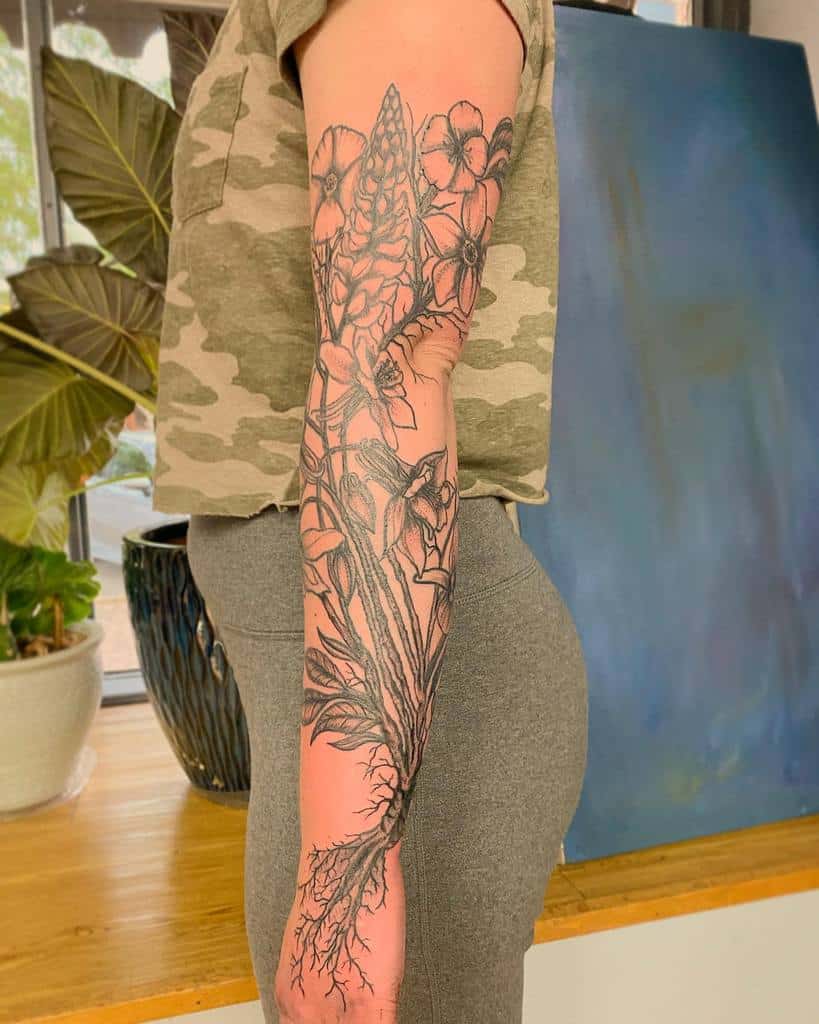 A stunning sleeve tattoo with a floral design, complete with intricate roots