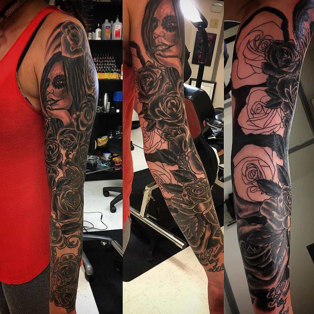 Black and gray full sleeve tattoo featuring roses, leaves, and a hauntingly detailed woman's face with a dramatic theme