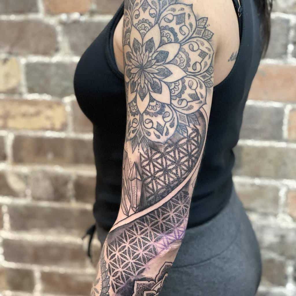 Elegant black-and-white sleeve tattoo showcasing intricate mandala patterns and geometric designs for a stunning, symmetrical look