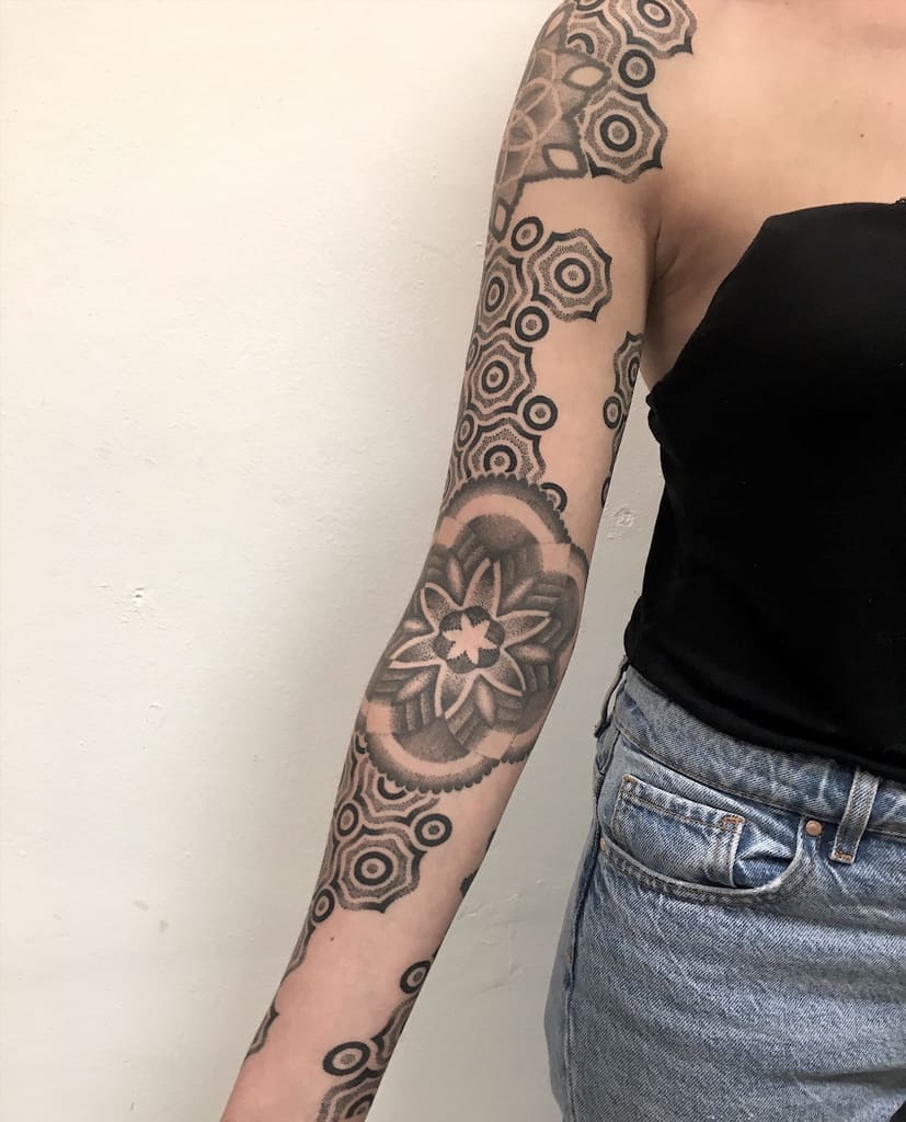 Woman with a geometric and floral sleeve tattoo