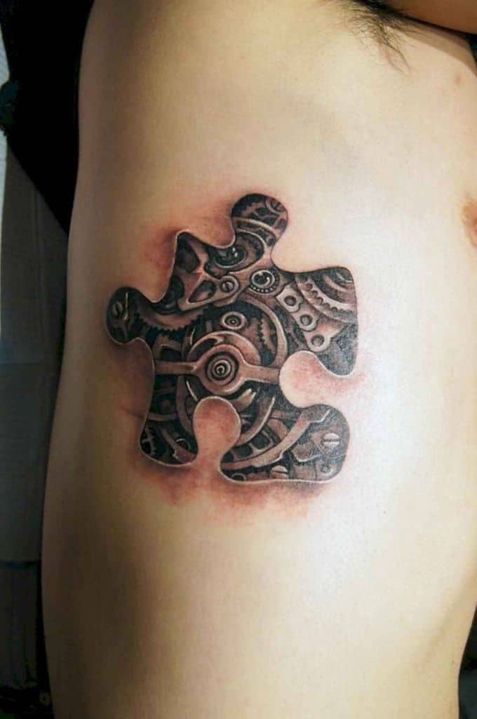Black and gray rib tattoo of a puzzle piece removed to show inner workings of a clock.