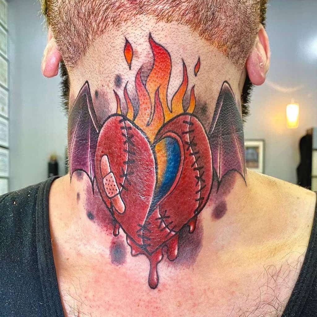 Colorful tattoo of a bleeding heart with bat wings and flames on the back of a person's neck