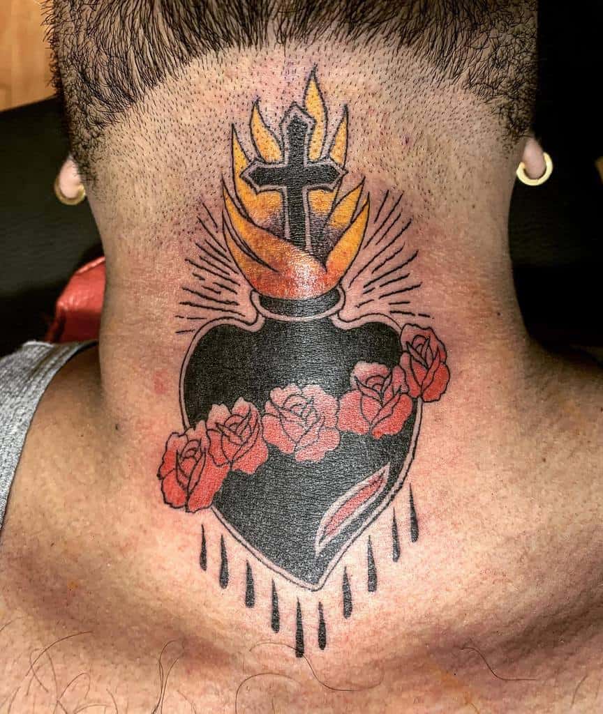 Tattoo of a flaming, bleeding heart with a cross, surrounded by roses, on the back of a person's neck