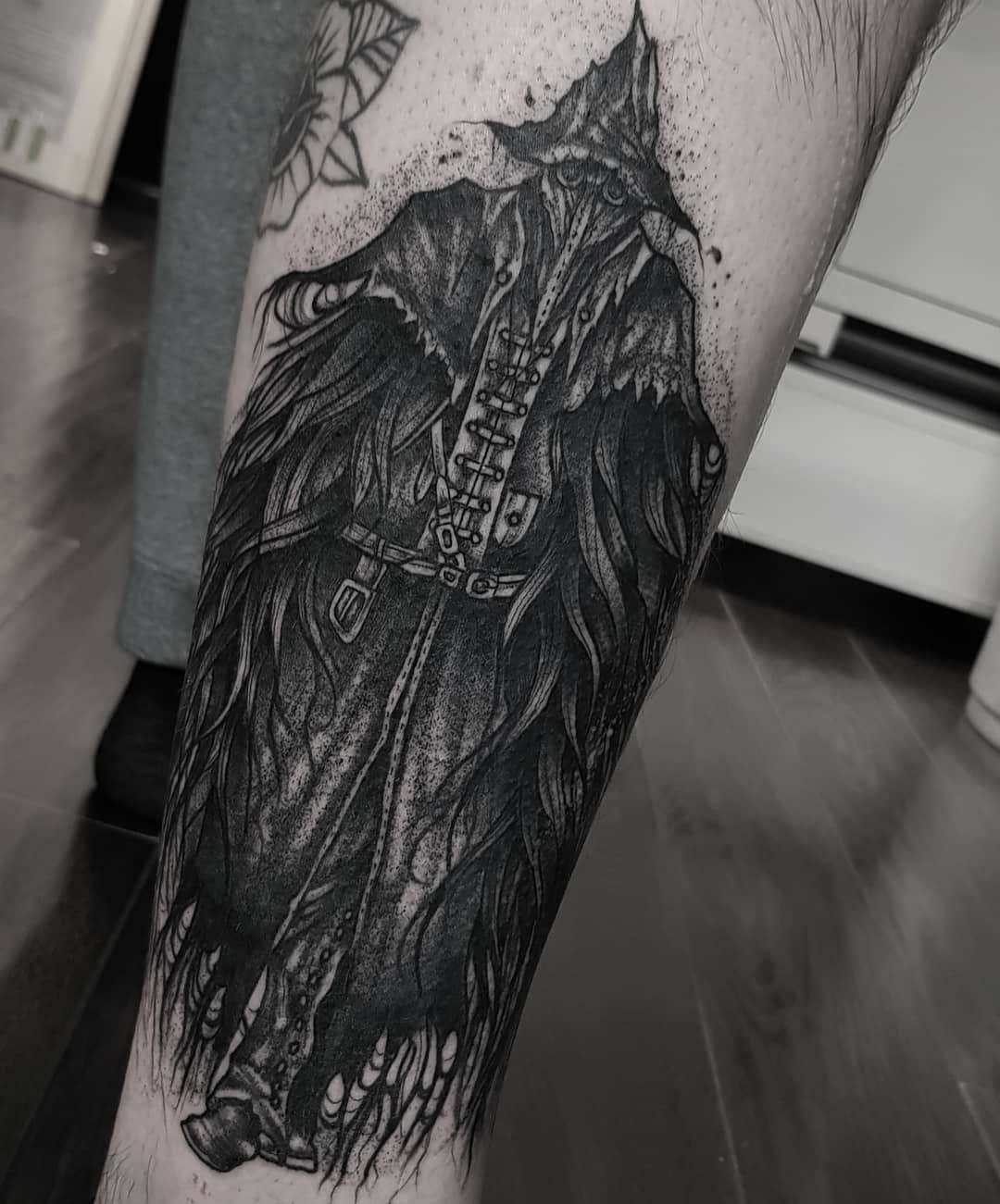 Black and grey tattoo of Eileen the Crow wearing a tattered cloak and beak-like mask