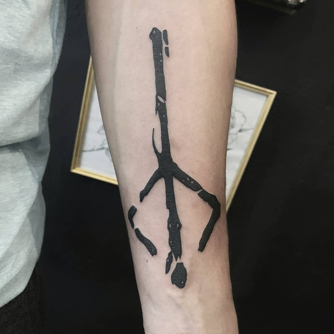 Simple and striking tattoo of the Bloodborne hunter's rune symbol in black on the forearm