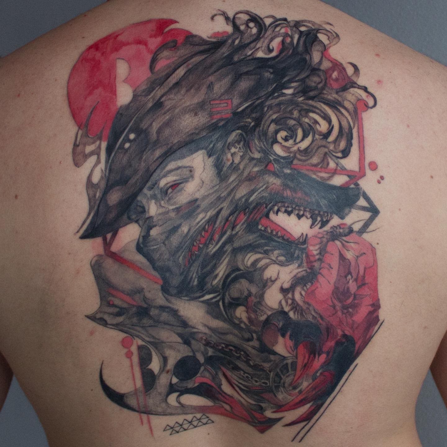 Intricate Bloodborne tattoo featuring a hunter's transformation into a snarling beast with red highlights