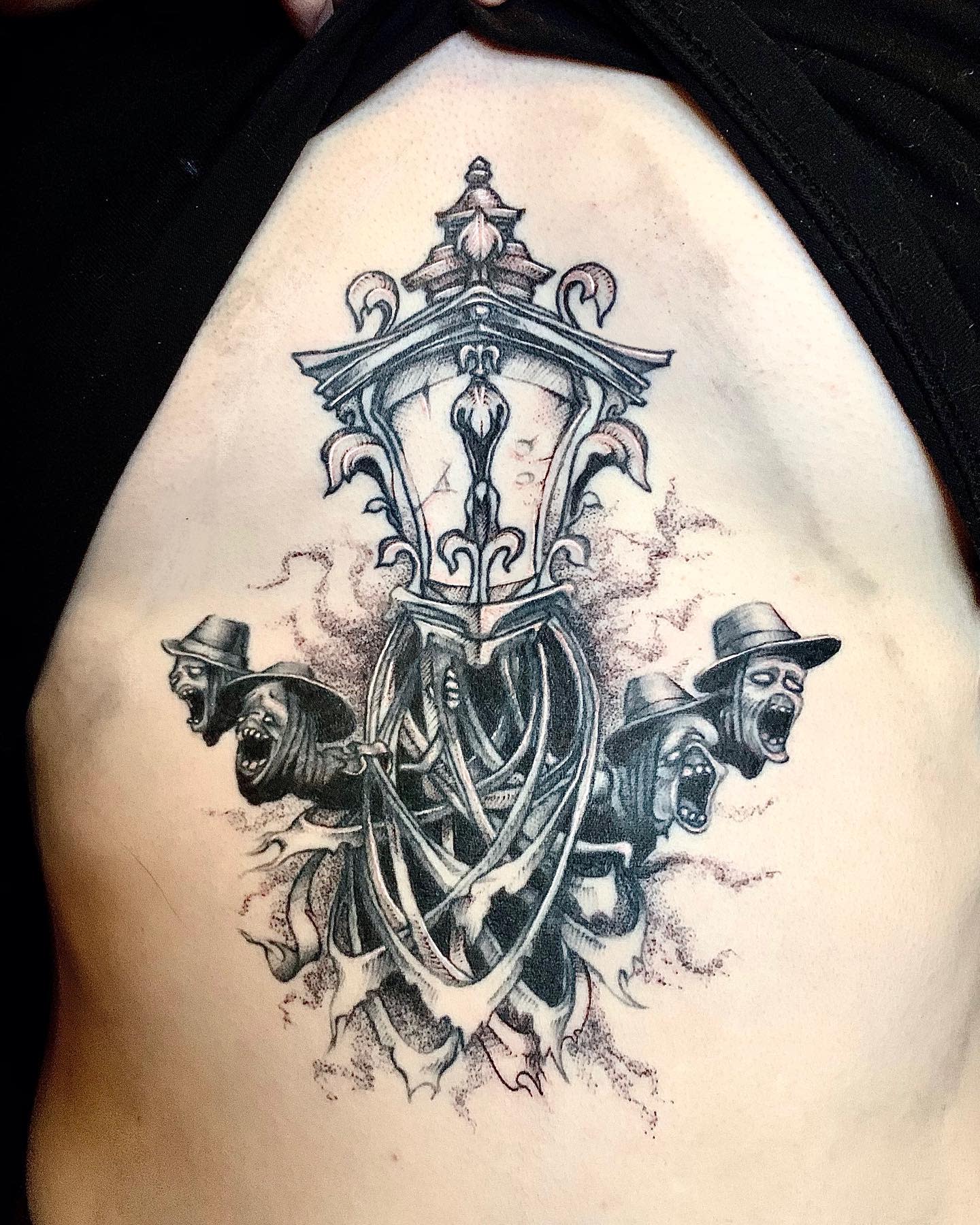 Chest tattoo of Bloodborne's iconic lantern entwined with Messengers wearing hats, emerging from the darkness