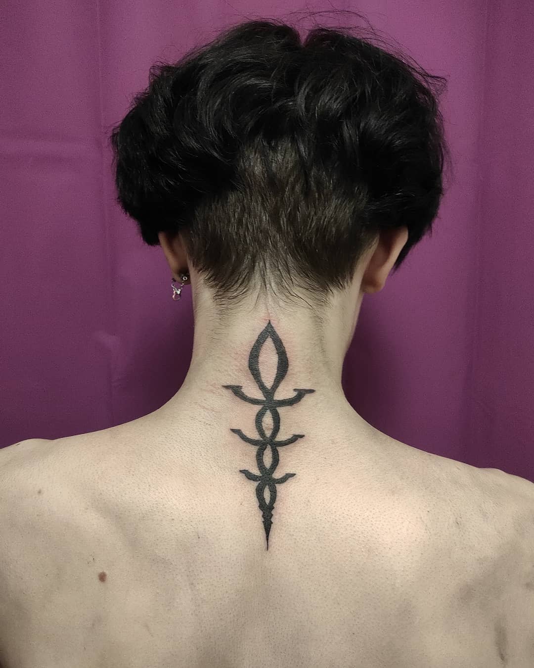 Back of the neck tattoo featuring a vertical Bloodborne rune symbol in bold black ink
