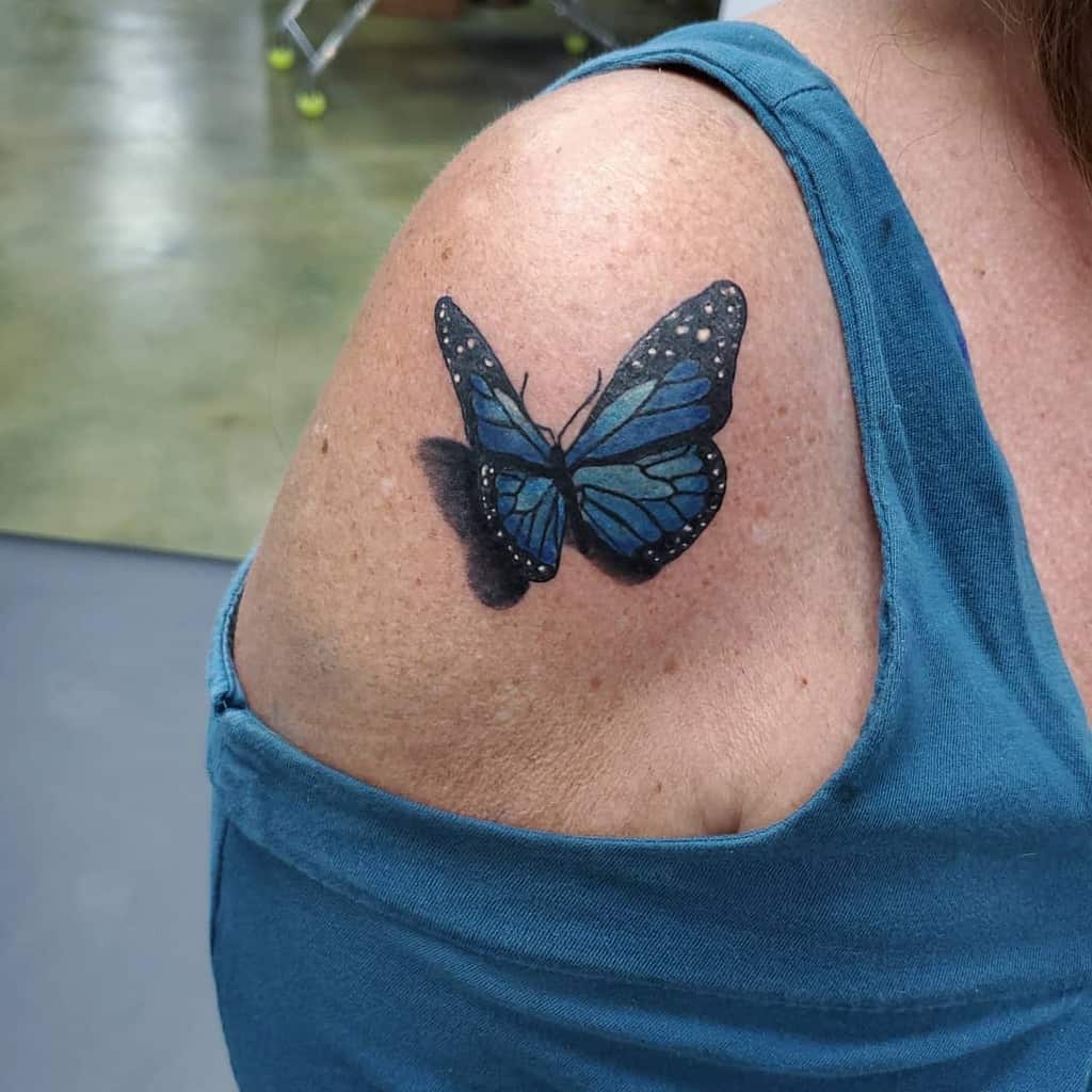 Blue butterfly tattoo on a shoulder