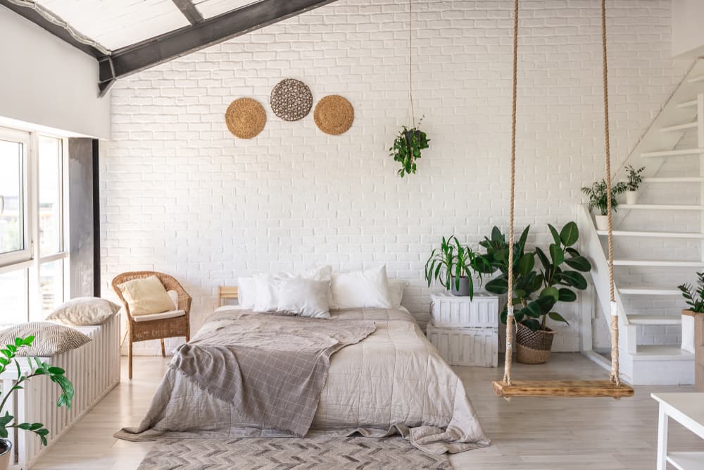 downstairs boho minimalist bedroom with swing seating