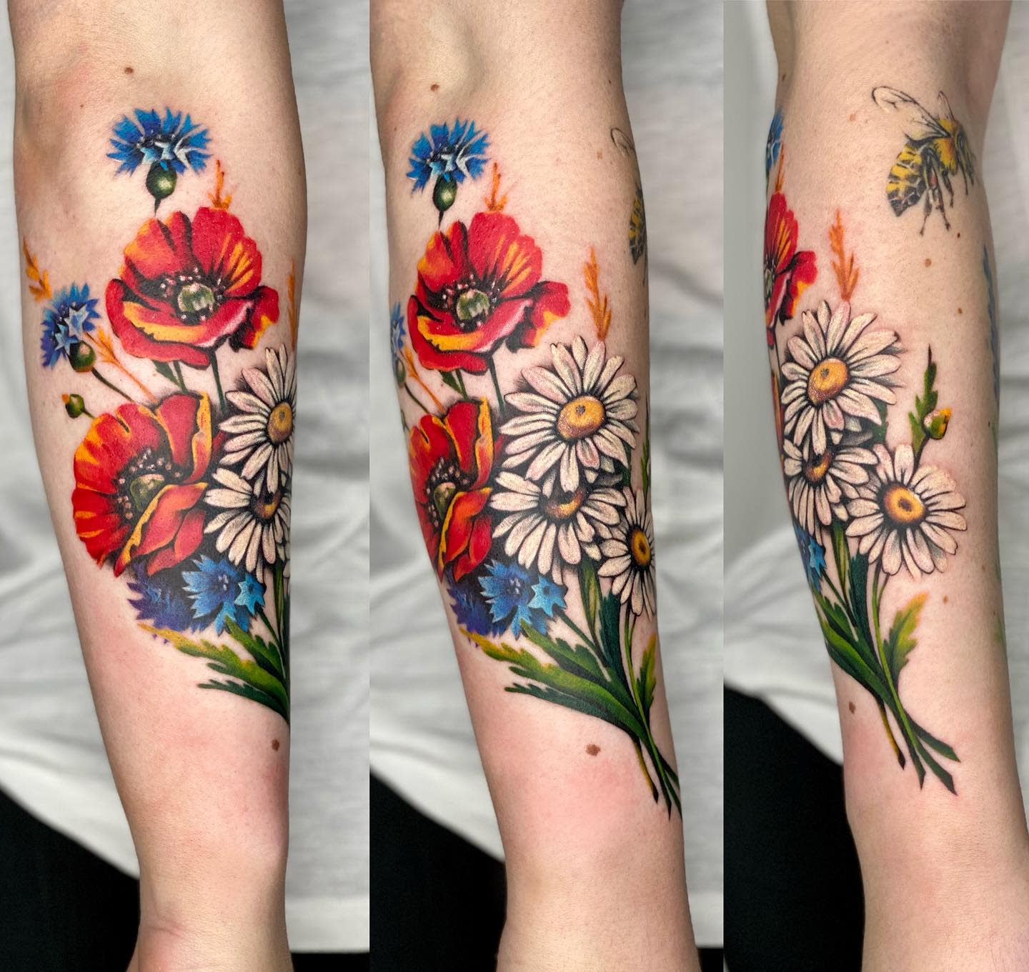 Forearm tattoo with colorful poppies, daisies, and blue flowers alongside insects