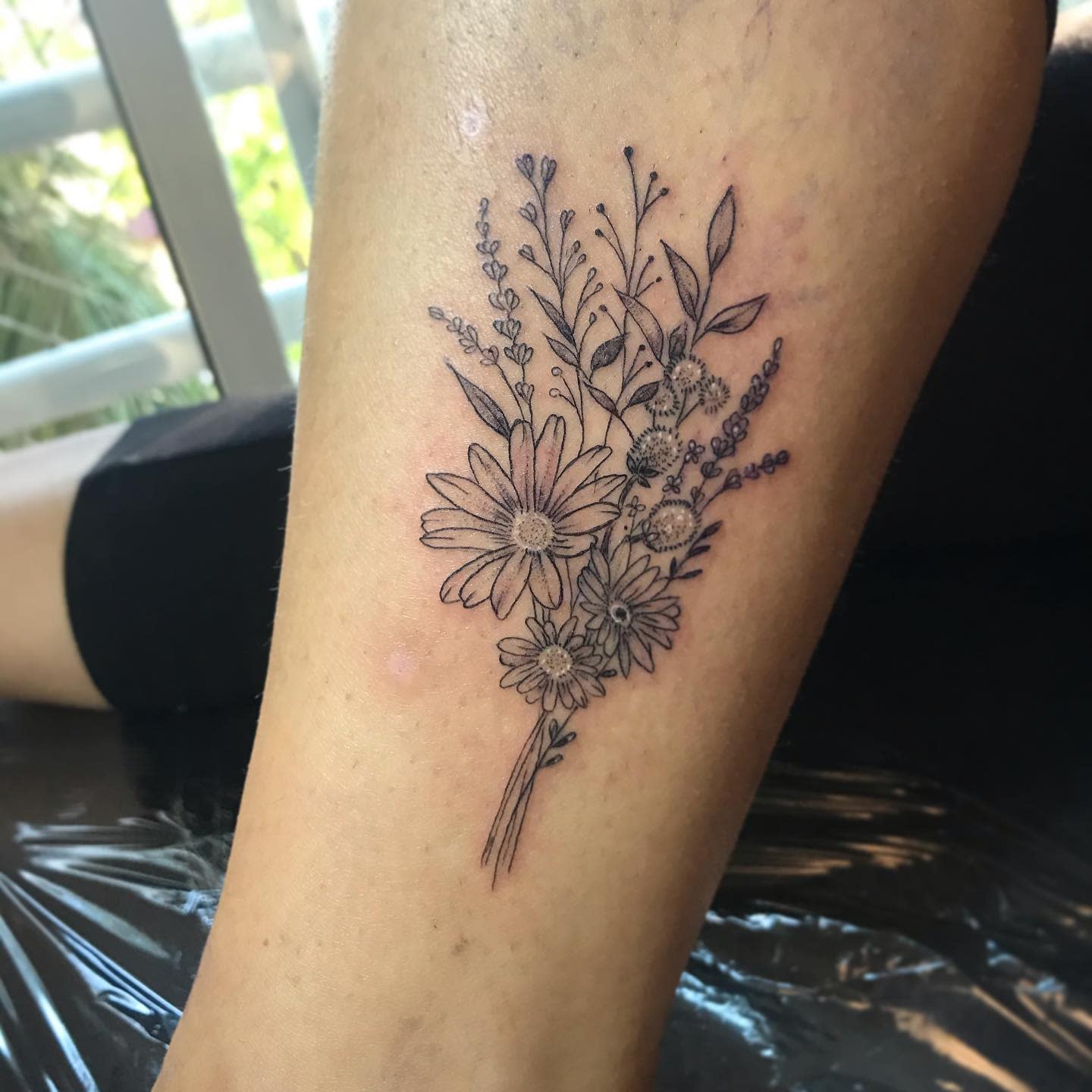 Black and white floral tattoo on a calf