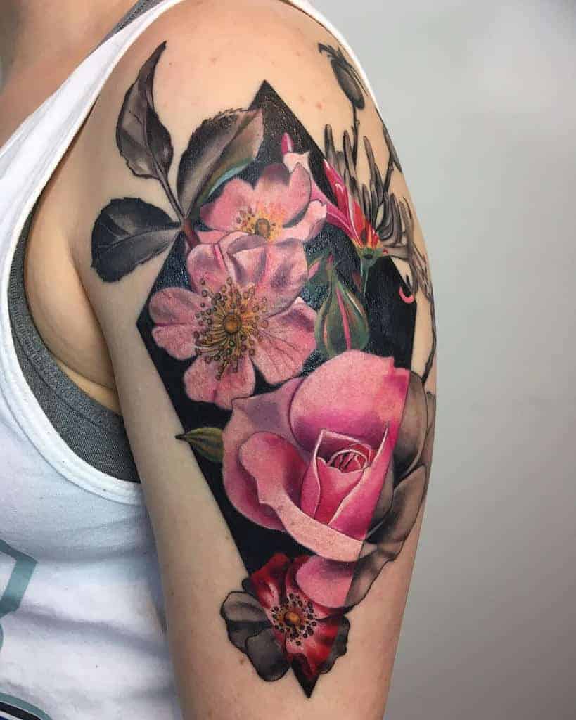 A vibrant and detailed botanical tattoo featuring honeysuckle and roses, beautifully blending pink hues with a bold black backdrop on the upper arm