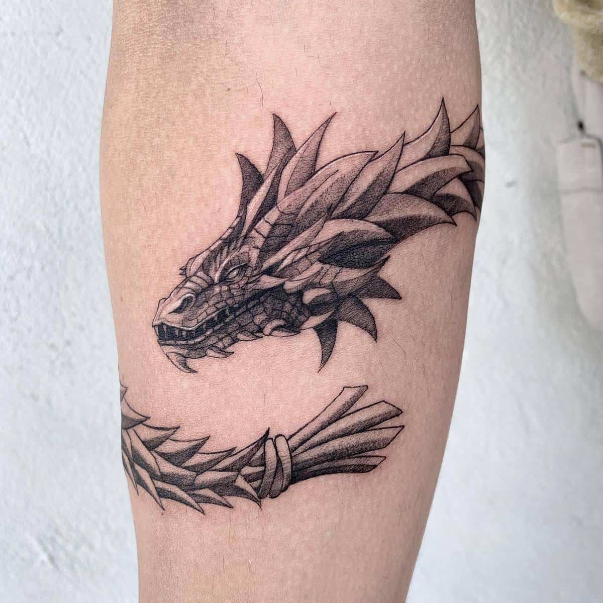 A tattoo featuring a stylized dragon head and a bundle of sticks on the right forearm