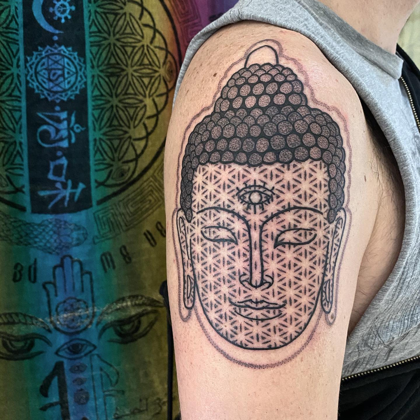 Buddha tattoo with intricate patterns on arm