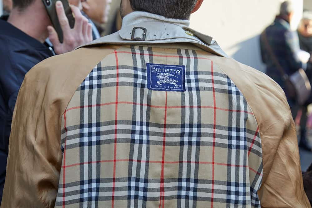 A man wears a Burberry trench coat at a fashion show in Milan, Italy.
