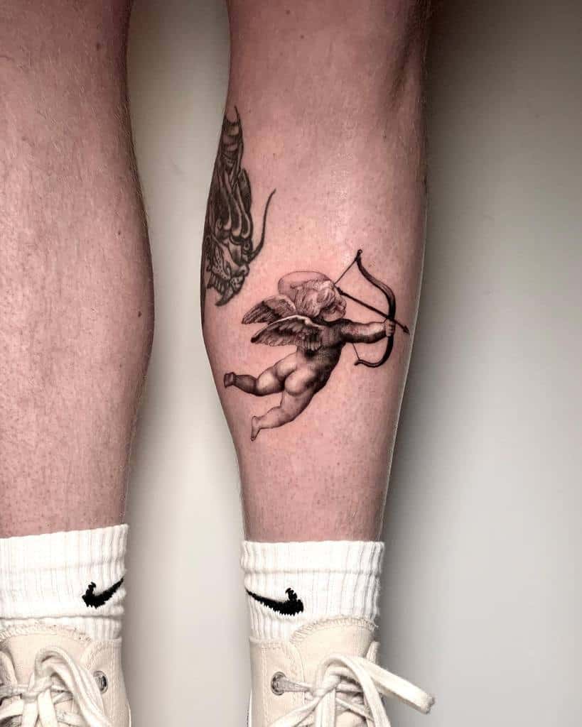 Tattoo of a cherub with a bow and arrow meticulously crafted in single needle style on the back of a person's calf