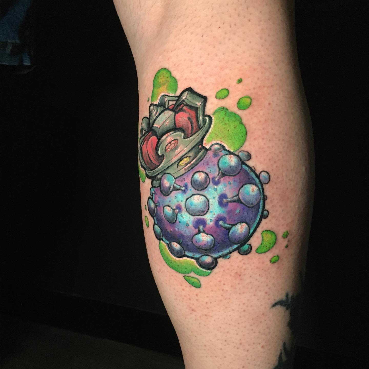 Colorful tattoo of a potion bottle with purple liquid and green splashes, on a leg