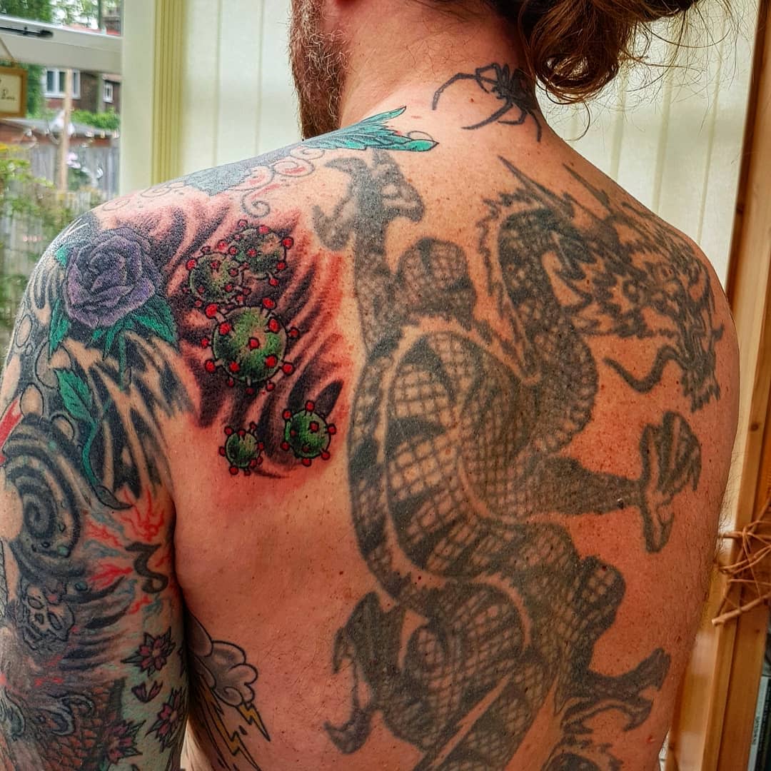 Cartoonish virus tattoo on man's back