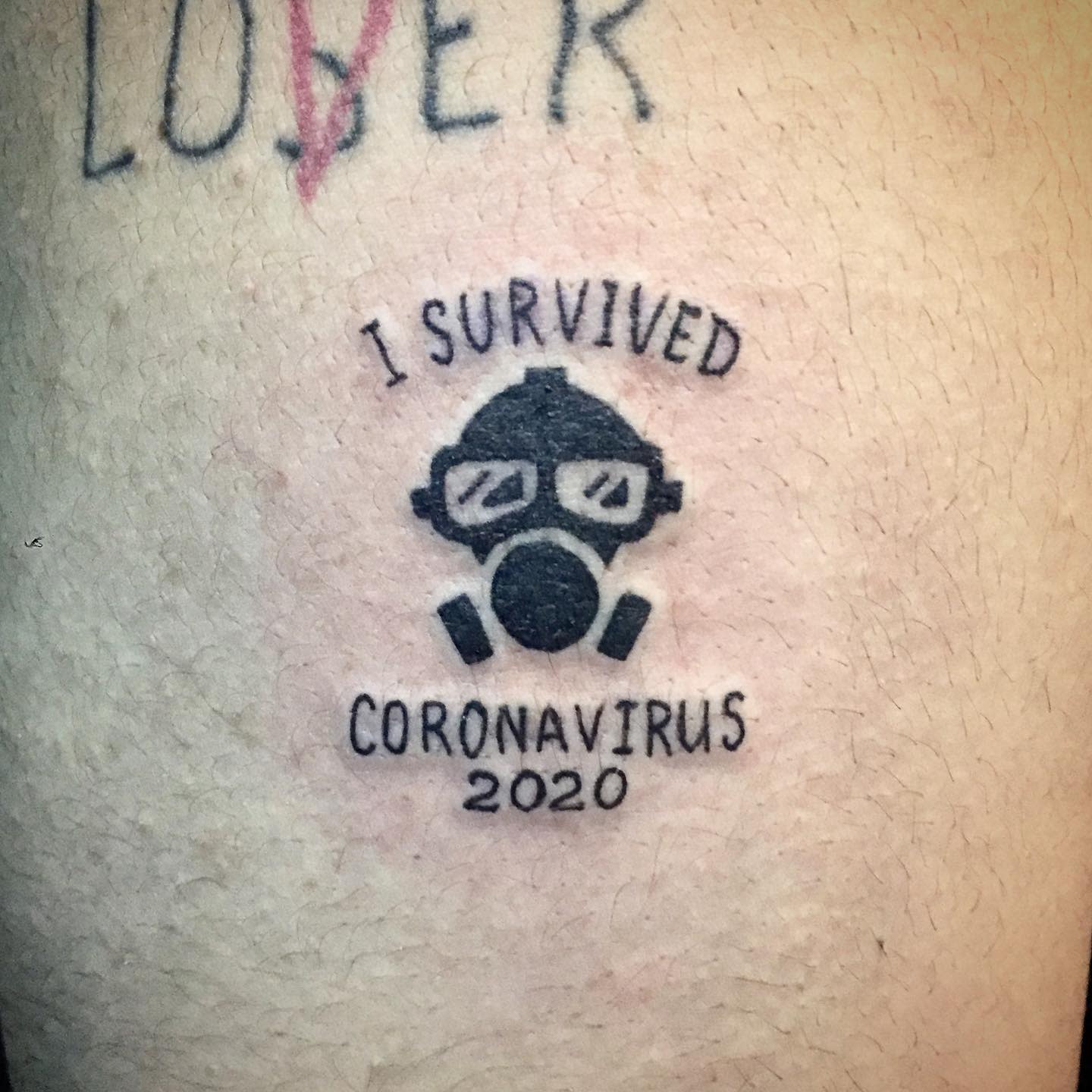 Tattoo of a gas mask with text "I Survived Coronavirus 2020" above and below it