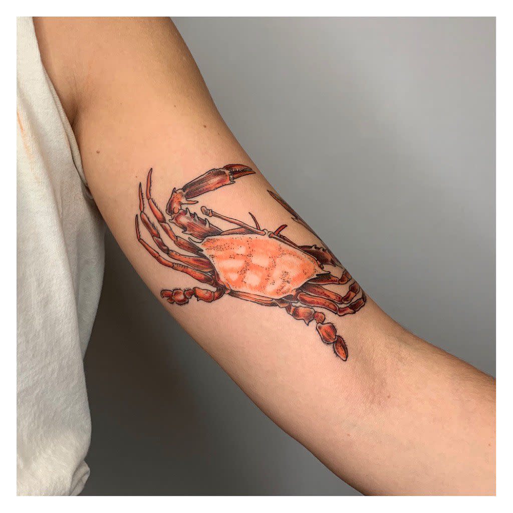 A lifelike depiction of a cancer intricately inked on the inner arm with pronounced textures and shading 