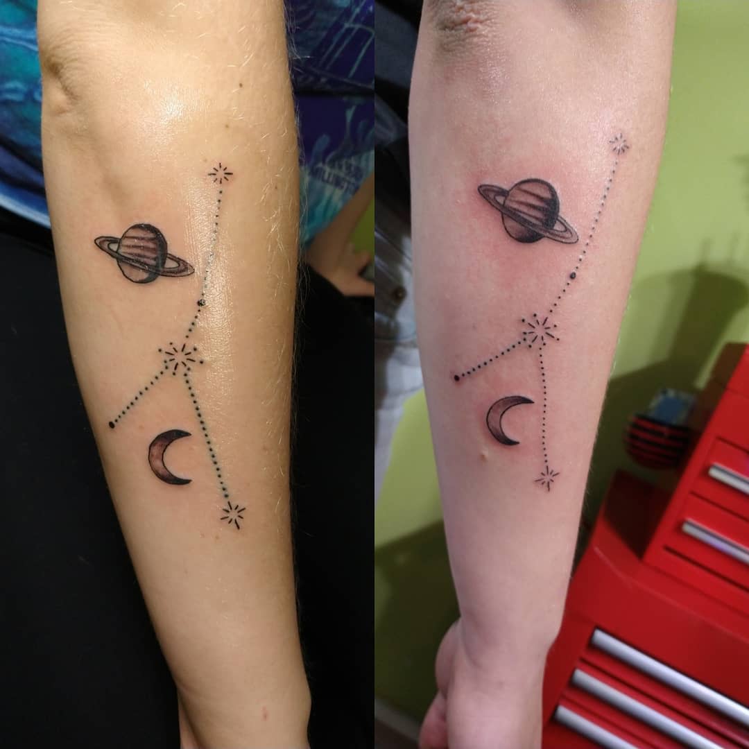 Forearm tattoo featuring Saturn, a crescent moon, and cancer zodiac constellation 