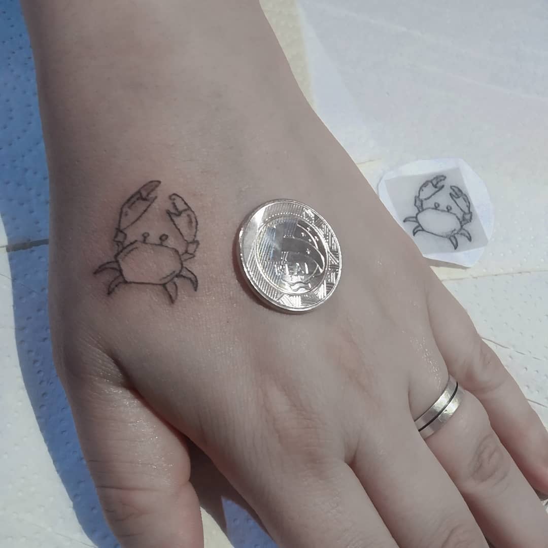 Small cancer tattoo on hand