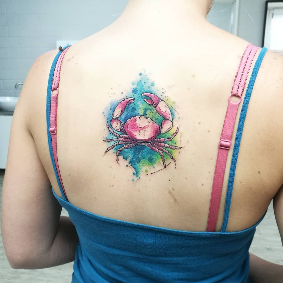 Woman with a colorful crab tattoo on her upper back