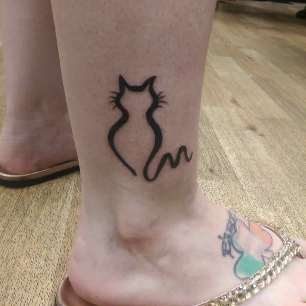 Tattoo of a black cat outline on an ankle