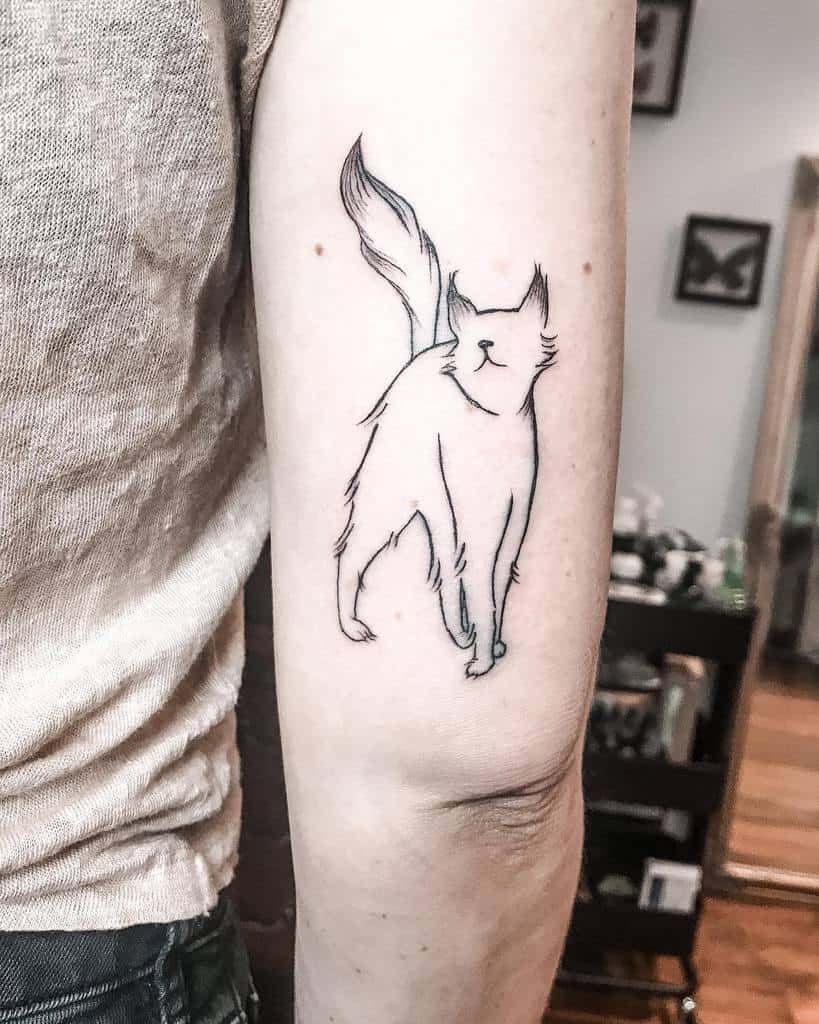 Minimalist black-ink outline tattoo of a sleek cat on an upper arm, featuring an elegant design