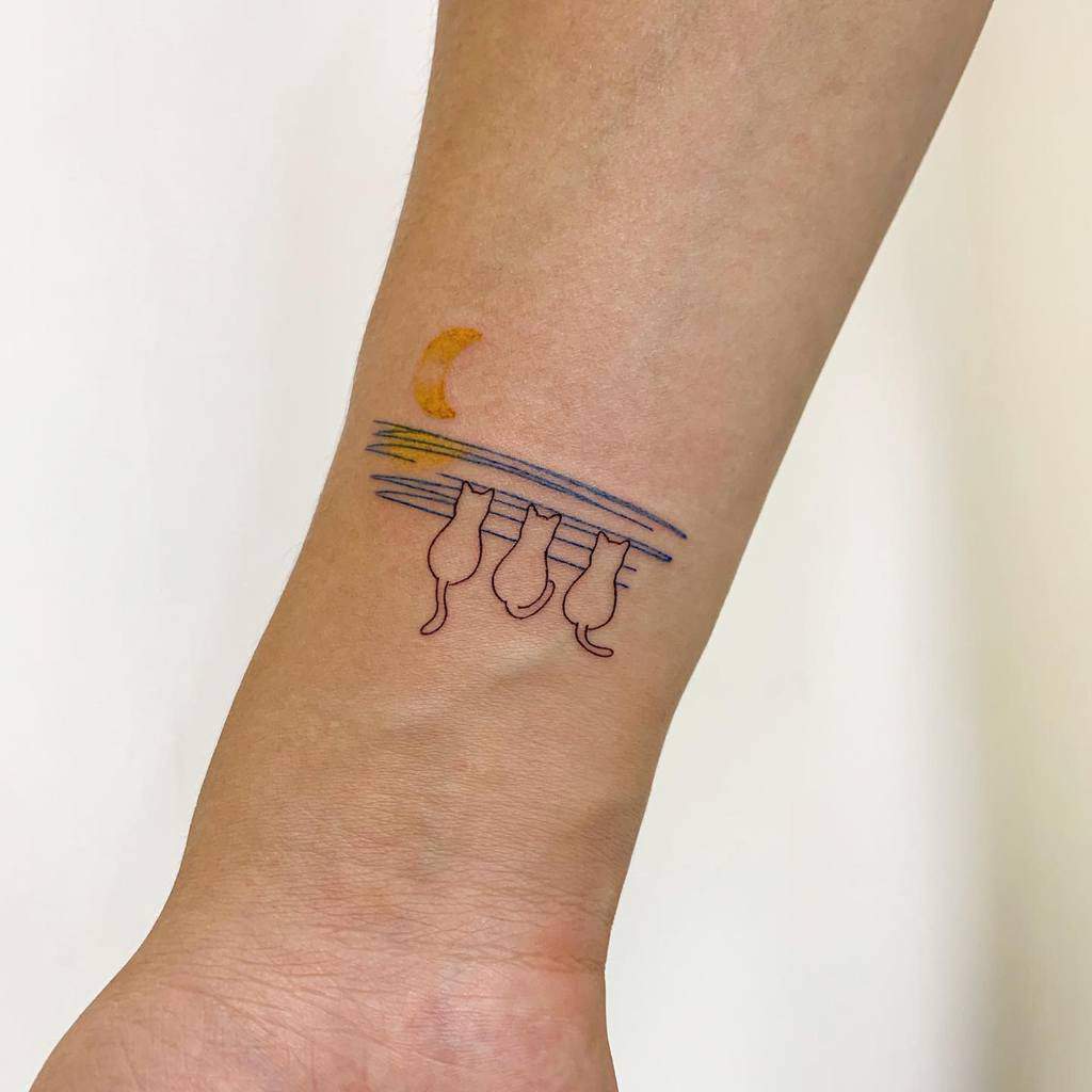 Tattoo of three cats on a branch under a crescent moon