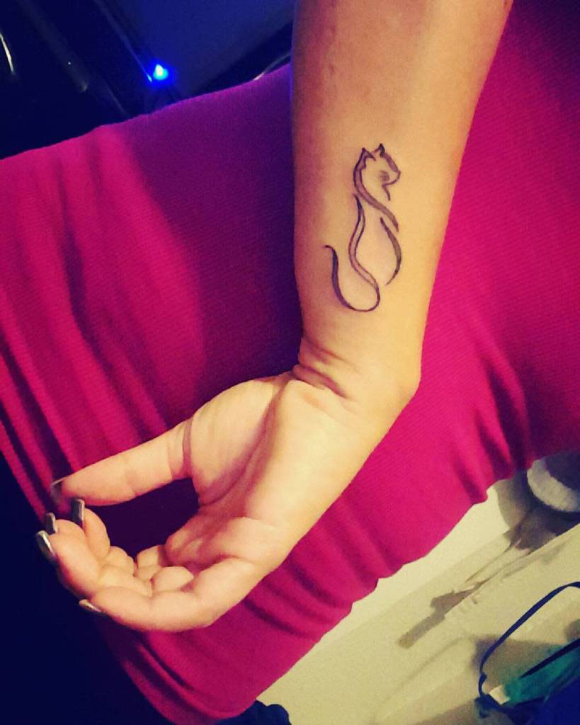 Outline of a cat tattoo on a wrist