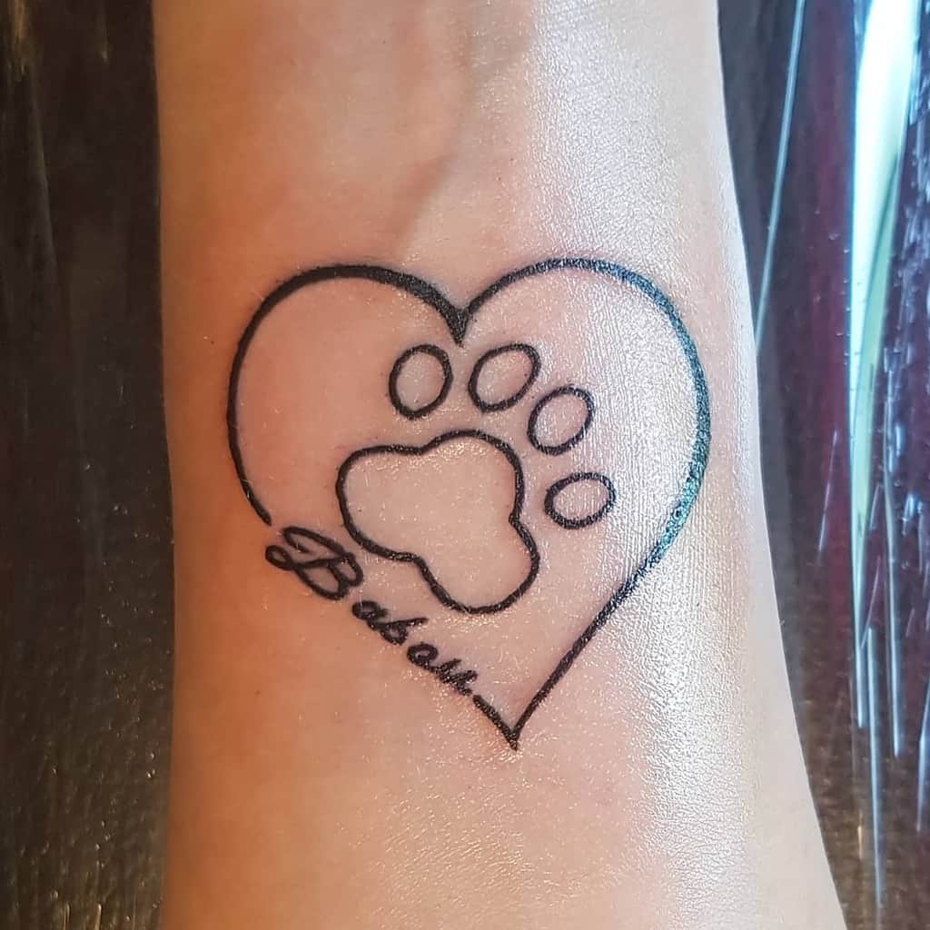 Tattoo of a heart with a cat paw print inside and the word "Babau" beneath it