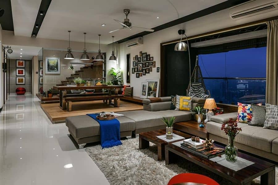 large luxurious living room dining room gray sofa brown table and bench fan pendant lights