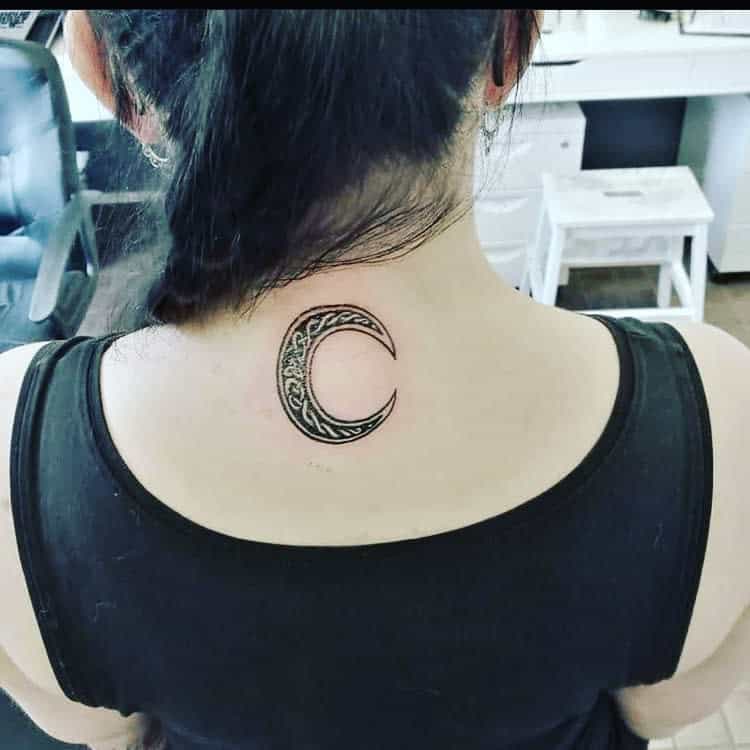 Crescent moon tattoo on the back of a woman's neck