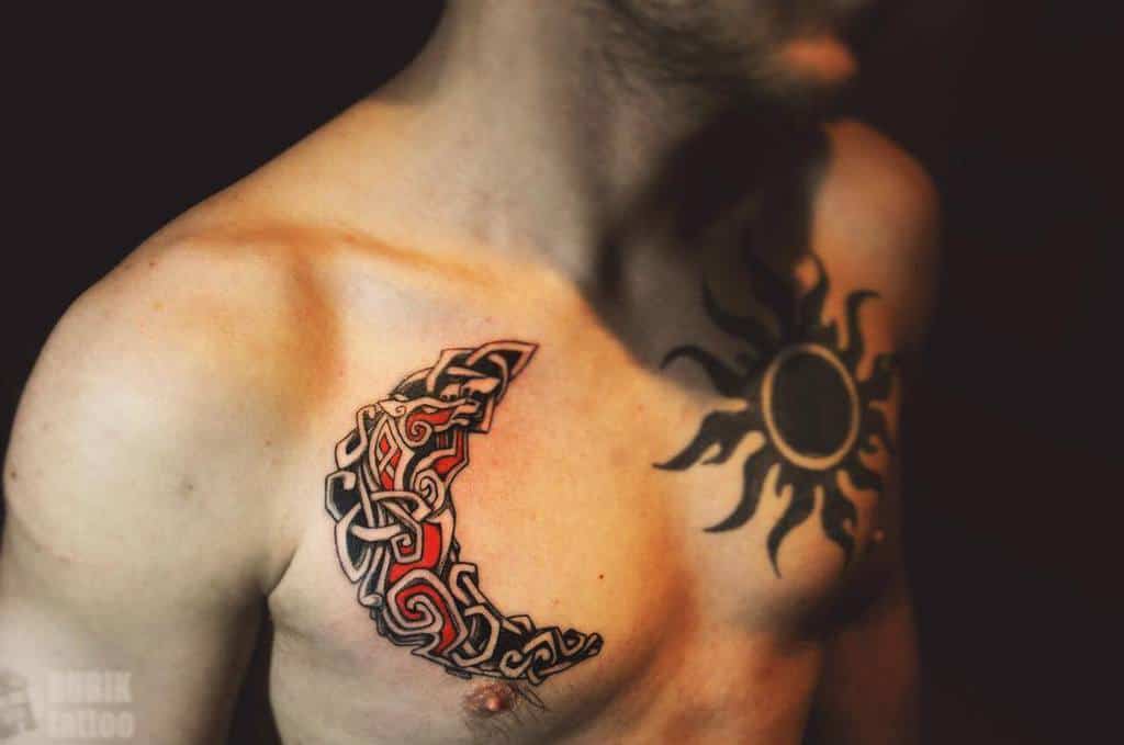 Man's chest with a tribal sun tattoo on the right and a decorative crescent moon adorning the left