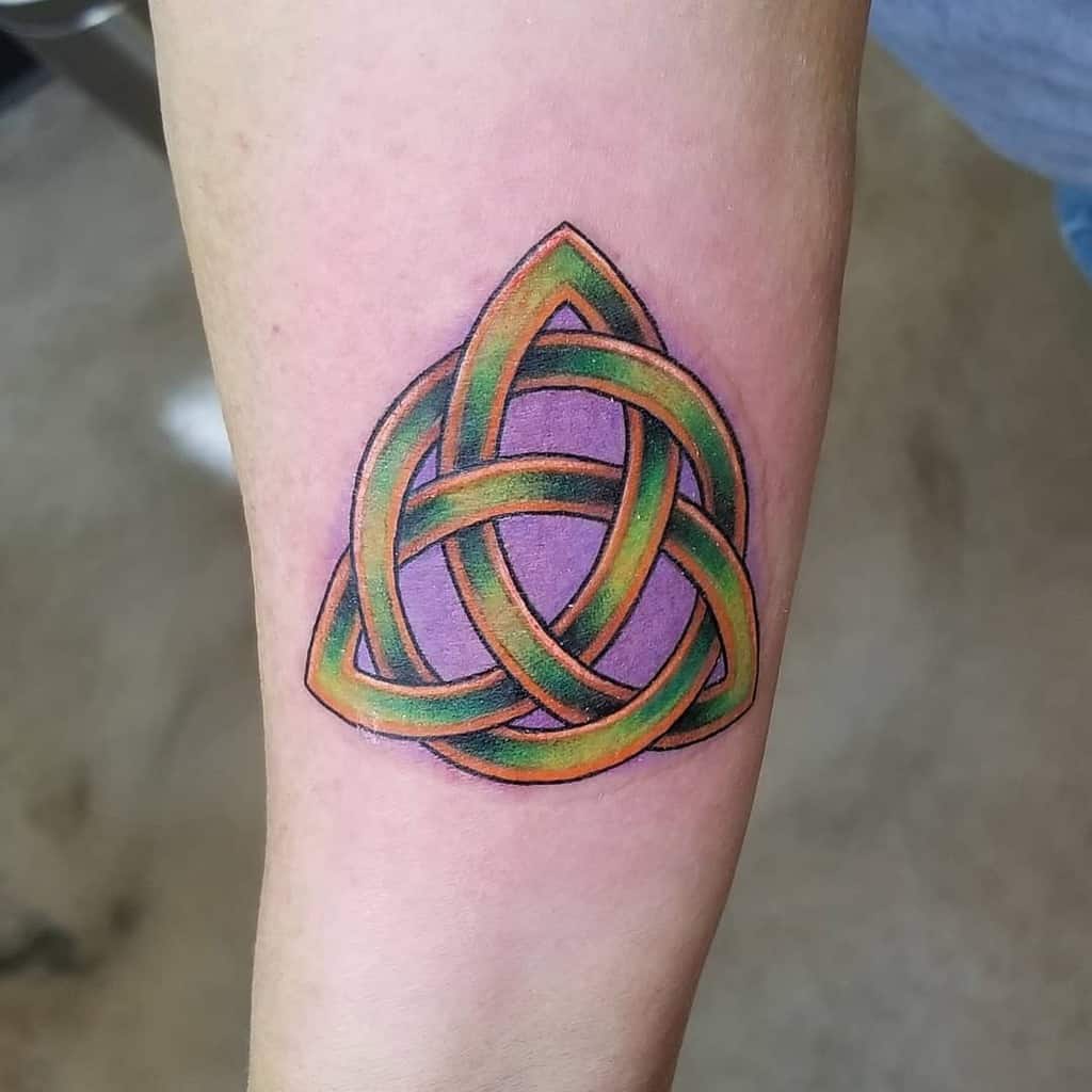 Celtic knot tattoo on forearm with green, yellow, and purple hues