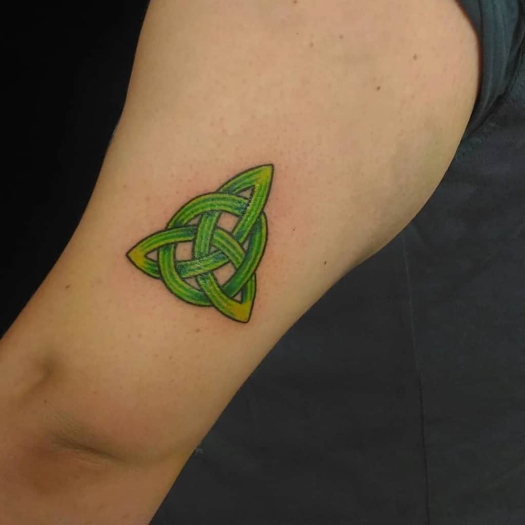 Green Celtic knot tattoo on upper arm