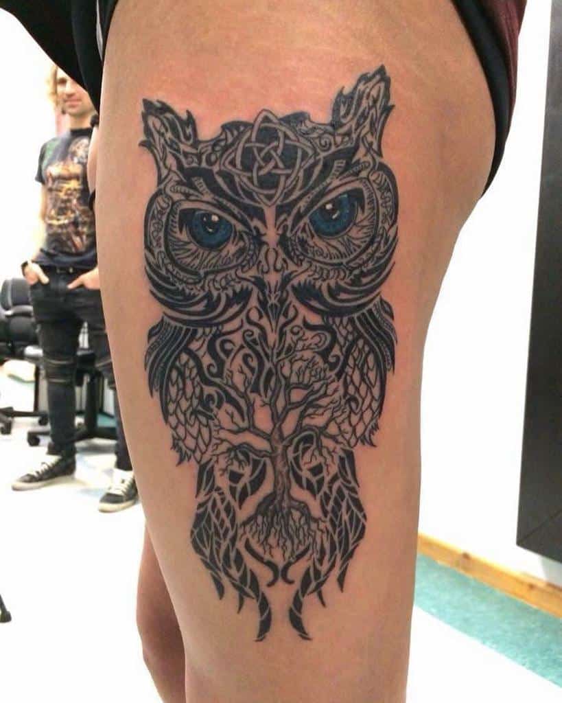 Detailed Scottish owl tattoo with blue eyes, Celtic knot accents, and a tree of life design integrated into its body