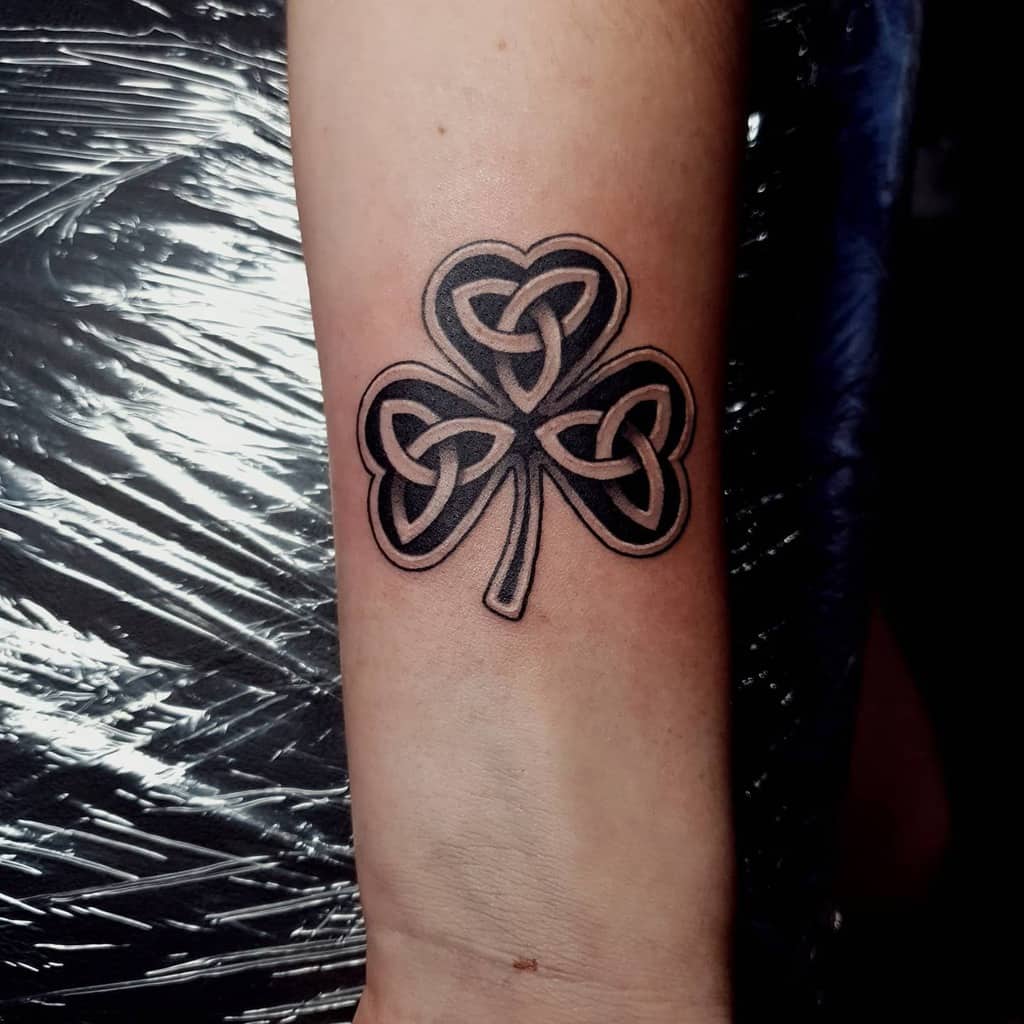 Black ink shamrock tattoo with intricate Scottish Celtic knotwork inside each leaf for a clean and bold look
