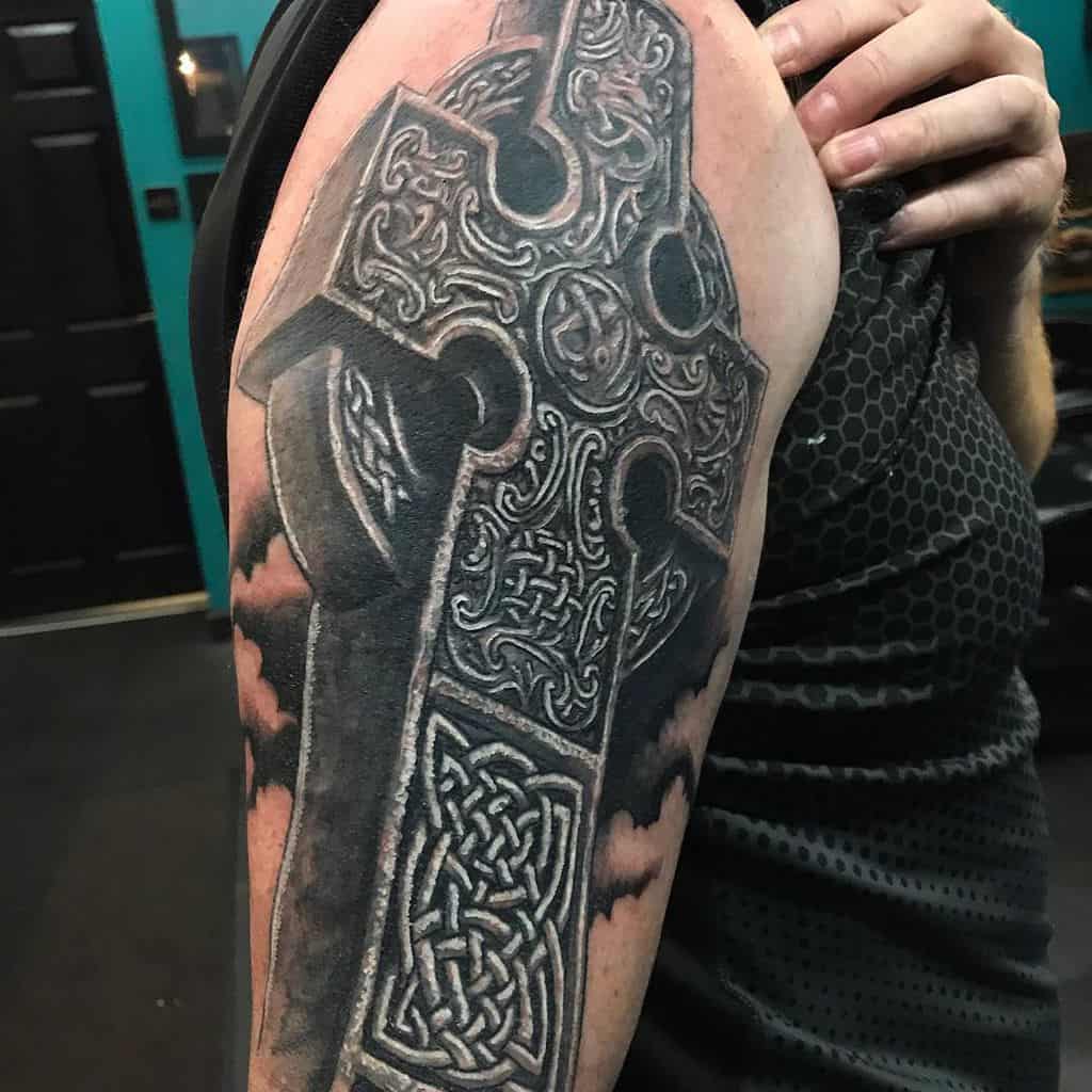 Realistic 3D Scottish Celtic cross tattoo with intricate knotwork, and bold black and grey details