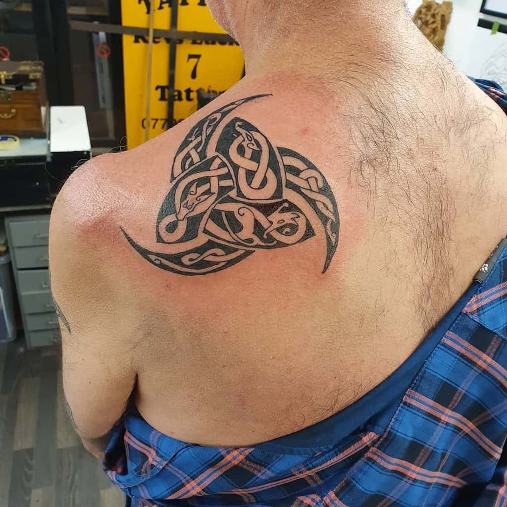 Large black ink Scottish Celtic triskelion tattoo featuring intertwined knotwork and snake designs