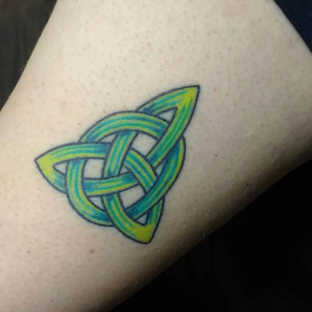 A green and yellow Scottish Celtic triquetra tattoo with a gradient effect, featuring interwoven lines