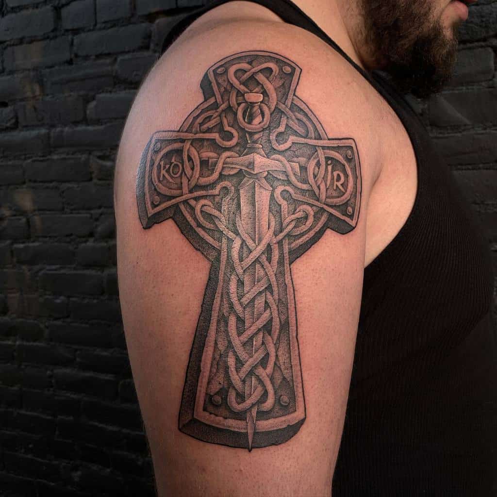 A Celtic cross tattoo with intricate knotwork adorns a man's upper arm