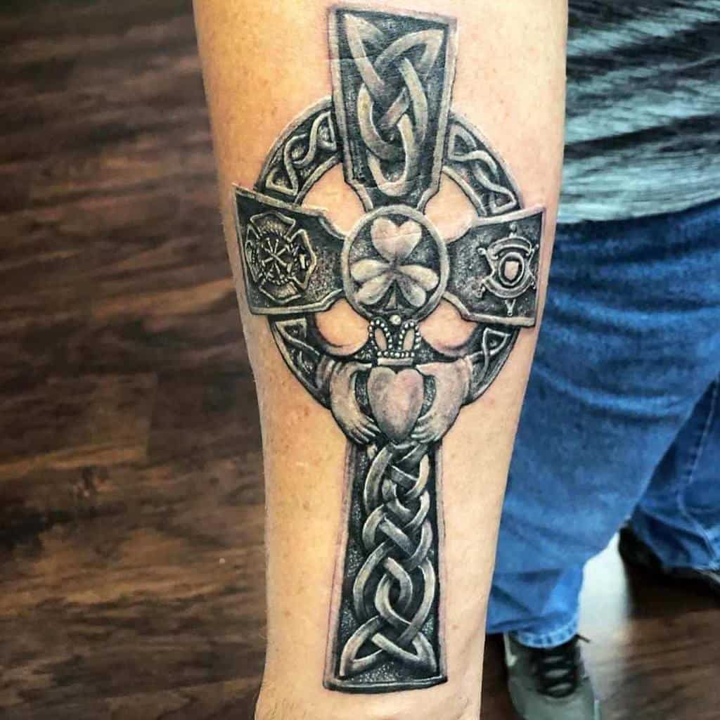 Celtic cross tattoo on the forearm, adorned with intricate knot designs and symbolic cross details