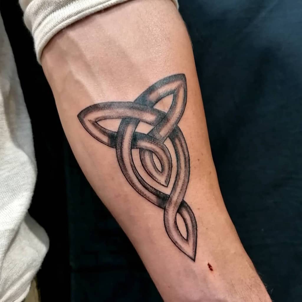 A Celtic triquetra tattoo on the forearm, featuring bold, interwoven lines and subtle shading to create depth and a modern look