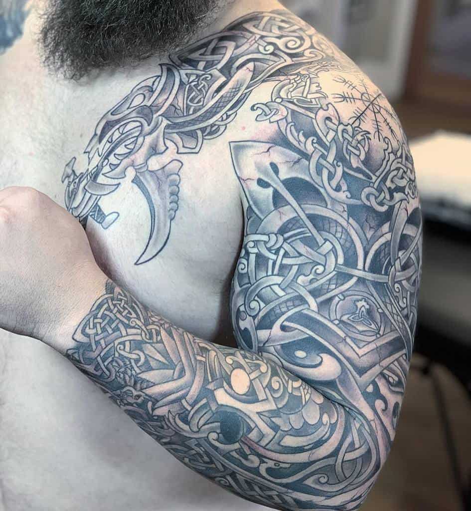 A detailed Celtic tribal sleeve tattoo that begins at the shoulder and extends down to the wrist